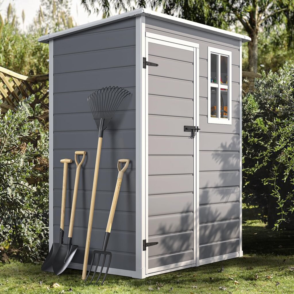 Organized garden tools, small furniture, and storage bins inside the YITAHOME resin shed.