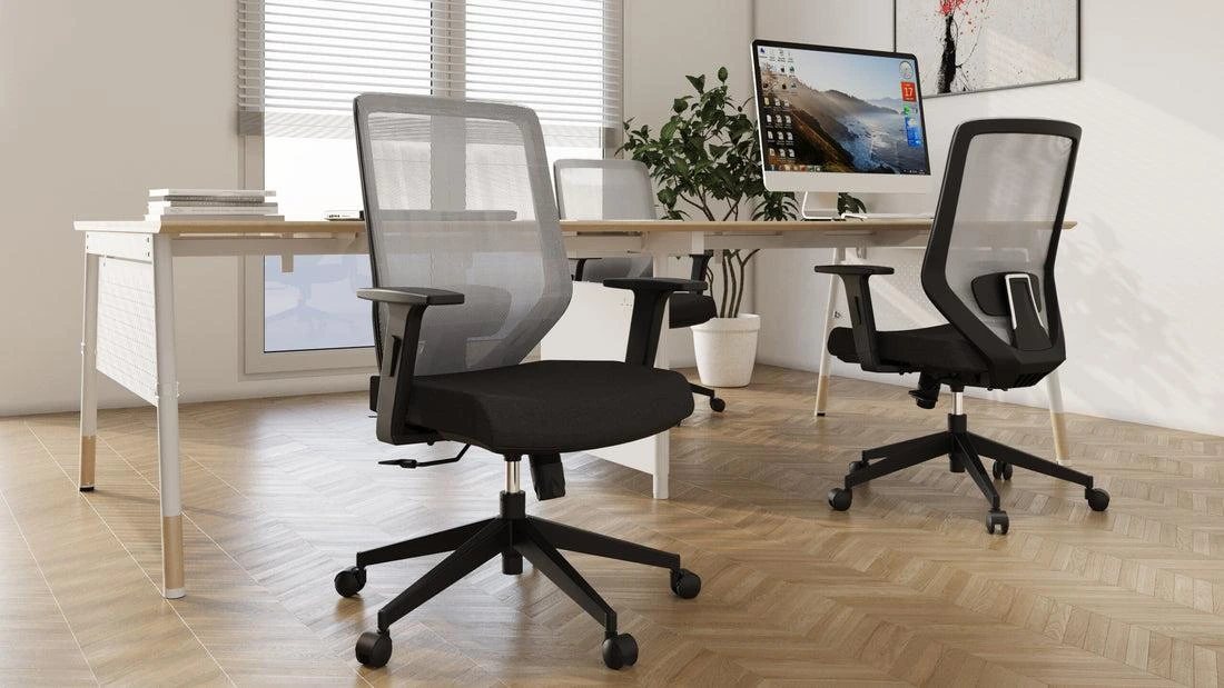 Two mesh-back ergonomic office chairs at a white desk, the kind of chair often discounted in Black Friday office chair deals